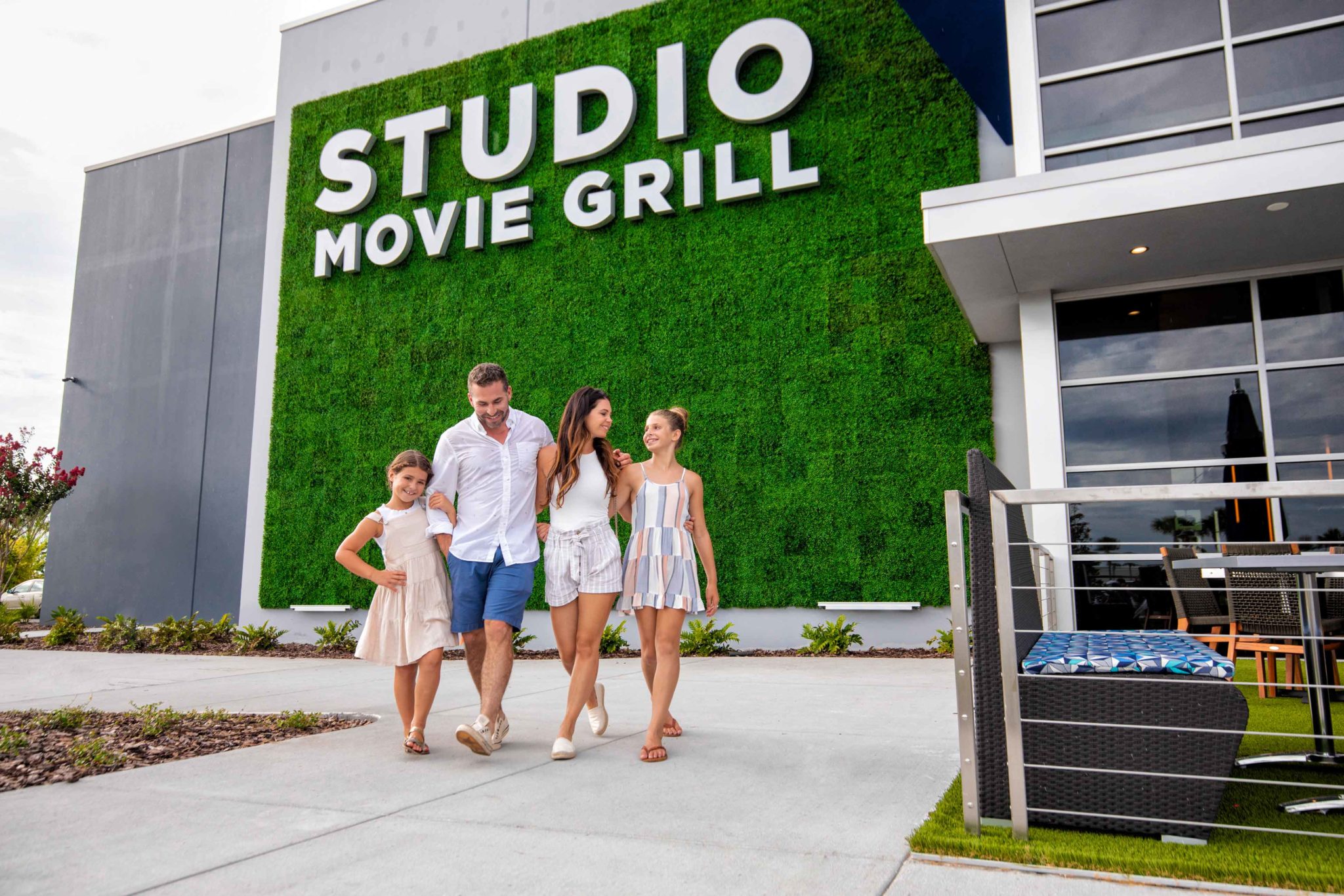 Family walking together outside Studio Movie Grill at the Promenade at Sunset Walk