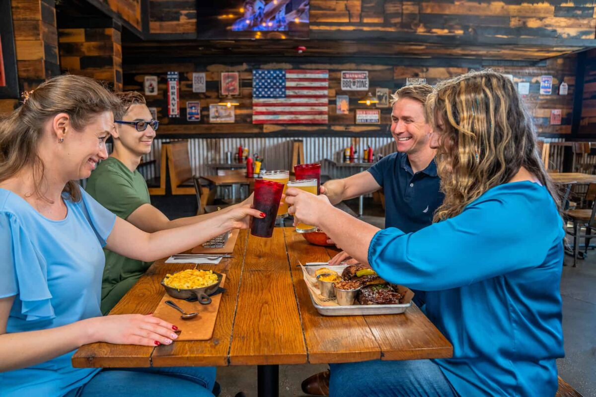 Group raising glasses in a toast at Lizzie’s Memphis Style BBQ